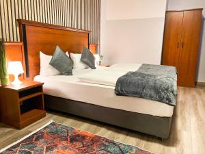 美因河畔法兰克福西部城市酒店的一间卧室配有一张大床和木制床头板
