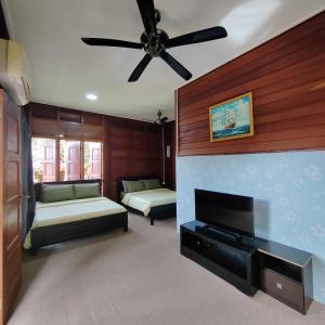 PedasD'Bukit Forest的客厅配有两张床和吊扇