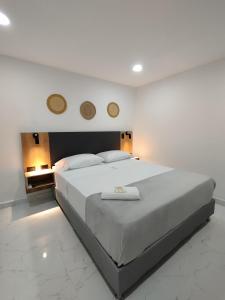 麦德林Zamá Room Hotel的卧室配有一张白色大床,墙上有两面镜子