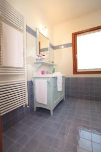 PolcenigoAlbergo Diffuso Polcenigo C.Barnard的蓝色瓷砖浴室设有水槽和镜子