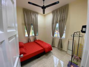 哥打丁宜BARAKAH HOMESTAY的一间卧室设有红色的床和2个窗户。