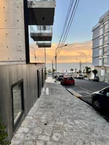 马德普拉塔Playa Grande Apartment的一条街道,汽车停在大楼的一侧