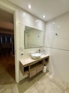 马德普拉塔Playa Grande Apartment的一间带水槽和镜子的浴室