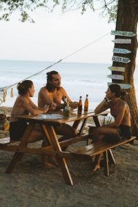 波波约Popoyo Republic的一群坐在海滩野餐桌上的人