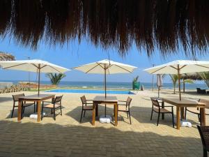 卡诺阿斯德蓬萨尔Hotel Gran Azul Bungalows的海滩上一组桌椅和遮阳伞