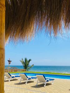 卡诺阿斯德蓬萨尔Hotel Gran Azul Bungalows的坐在海边的一排椅子