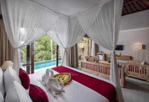 德格拉朗Kawi Resort A Pramana Experience的一间带大床的卧室和一个游泳池