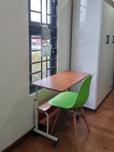 邦美蜀Gachilly House - Your Cozy Home In The Heart Of The BMT City的书桌和窗前的绿椅