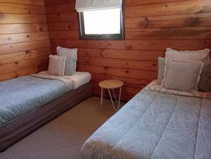 罗托鲁瓦Cosy in central Rotorua的小木屋内带两张床的房间
