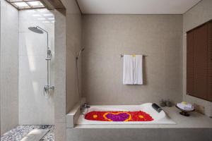 德格拉朗Kawi Resort A Pramana Experience的浴室配有鲜花盛开的浴缸。