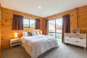 玛普瓦Sea Breeze的卧室设有木墙、一张床和窗户