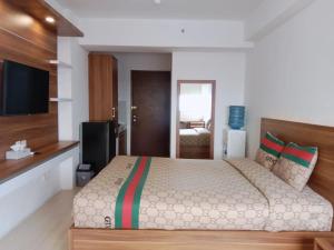 ParungdengdekSansan Room - Apartemen Gunung Putri Square的一间卧室配有一张大床和电视