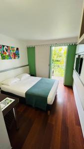 圣吉尔莱班Hotel Exsel Alamanda的一间卧室设有一张大床和一个窗户。
