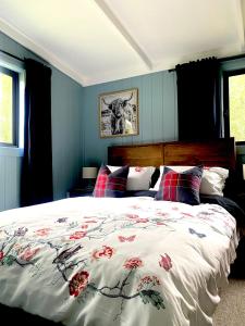 MoonbahJindabyne - Kia Ora Cabin Farmstay的一间卧室配有一张红色鲜花的大床