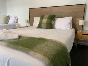 Meeniyan美尼炎汽车旅馆的一间卧室配有两张带绿色和白色枕头的床