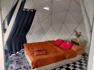 Mon JamMonteadeo Camping的一间卧室配有一张带红色枕头的床