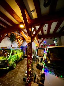 里加Urban Van Glamping Riga的两辆绿色货车停在一个配有圣诞灯的车库