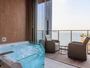 NishinouraAlba HOTEL & Glamping的海景客房内的热水浴池