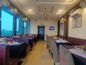 AshoknagarHotel Ahinsa Palace, Ashoknagar的用餐室配有桌椅和紫色桌布