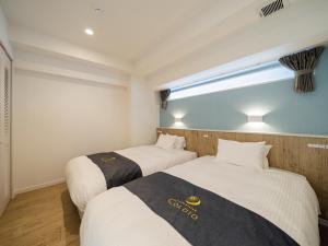 北谷町Aqua Palace Chatan by Coldio Premium的带窗户的客房内的两张床