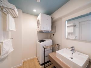 北谷町Aqua Palace Chatan by Coldio Premium的一间带水槽、洗衣机和烘干机的浴室