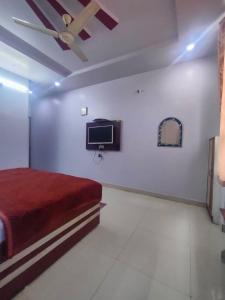 AnūppurHOTEL KANHA INTERNATIONAL, Anuppur的卧室配有一张床,墙上配有电视。