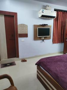 AnūppurHOTEL KANHA INTERNATIONAL, Anuppur的卧室配有一张床,墙上配有电视。