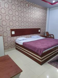 AnūppurHOTEL KANHA INTERNATIONAL, Anuppur的一间卧室配有一张带紫色棉被的床