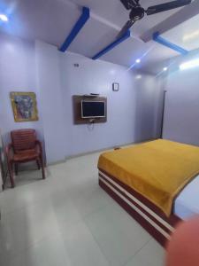 AnūppurHOTEL KANHA INTERNATIONAL, Anuppur的一间卧室配有一张床、一台电视和一把椅子