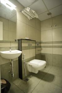 埃尔讷古勒姆Sulu Residency的一间带水槽、卫生间和镜子的浴室