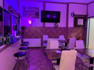 美因河畔法兰克福西部城市酒店的餐厅拥有紫色灯光和桌椅