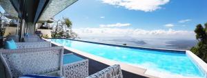 大雅台塔盖泰湖景酒店的一个带椅子的游泳池,享有海景