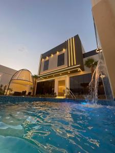 布赖代شاليه الرتاج الفندقي的大楼前带游泳池的房子