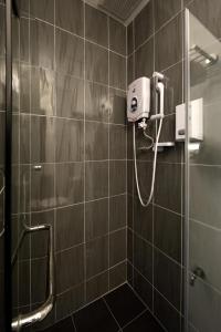 马六甲探索者酒店的墙上设有带吹风机和淋浴的浴室