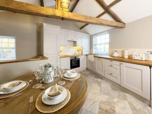 利兹Whitkirk Cottage的厨房配有木桌和餐具