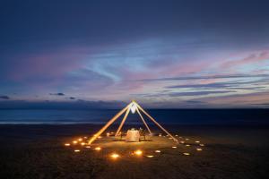 蔻立Kantary Beach Hotel Villas & Suites的海滩上的帐篷,晚上有灯光