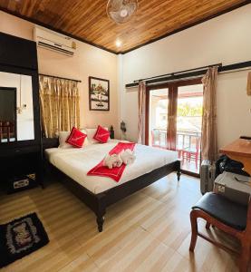 琅勃拉邦Singrarat Hotel的一间卧室,床上放着两只动物