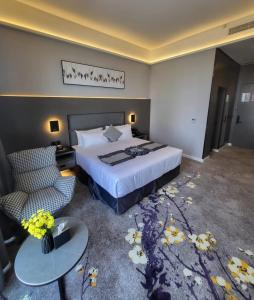 利雅德Msharef almoden hotel فندق مشارف المدن的酒店客房带一张床、一张桌子和椅子