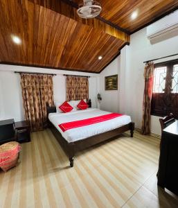 琅勃拉邦Singrarat Hotel的一间卧室设有一张大床和木制天花板