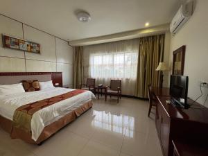 努库阿洛法Meida Hotel的酒店客房,配有床和电视