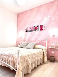 斯卡莱阿Minù house的卧室配有白色床和粉红色墙壁