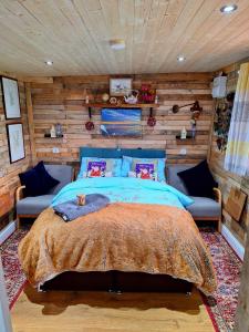 SwafieldLILAC COTTAGE cabin的一间卧室设有一张床和木墙