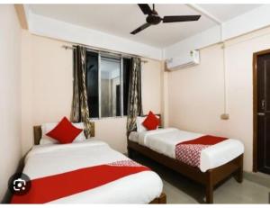 帕西加特Serene Guest House, Pasighat, Arunachal Pradesh的宿舍间内的两张床,配有红色枕头