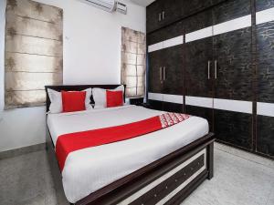 库卡特帕尔莱OYOFlagship Hillside Hotel Kukatpally的一间卧室配有一张带红色枕头的大床
