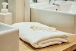 广岛Hostel Mange Tak的浴室的台面上摆放着一堆毛巾