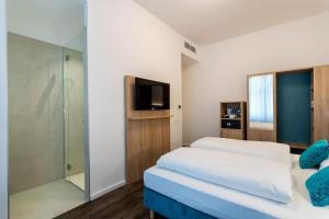 维也纳DaunTown Rooms - Self Check-In的一间卧室设有两张床和玻璃淋浴间