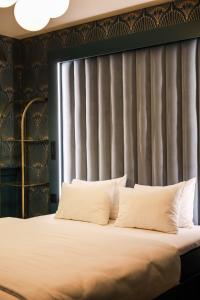 哈瑟尔特域普酒店的客房内的一张带白色枕头的床
