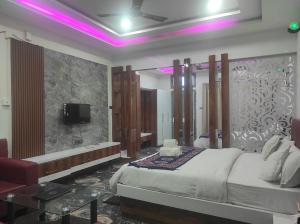 MargheritaHOTEL SG HUB TOWER的一间卧室配有一张床,并在一间客房内配有电视。