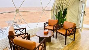 BadīyahMilky way Domes Desert Camp的客房享有沙漠美景,配有桌椅。