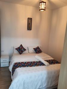 Kitengela The Crib House-Kitengela的卧室配有带枕头和吊灯的白色床。